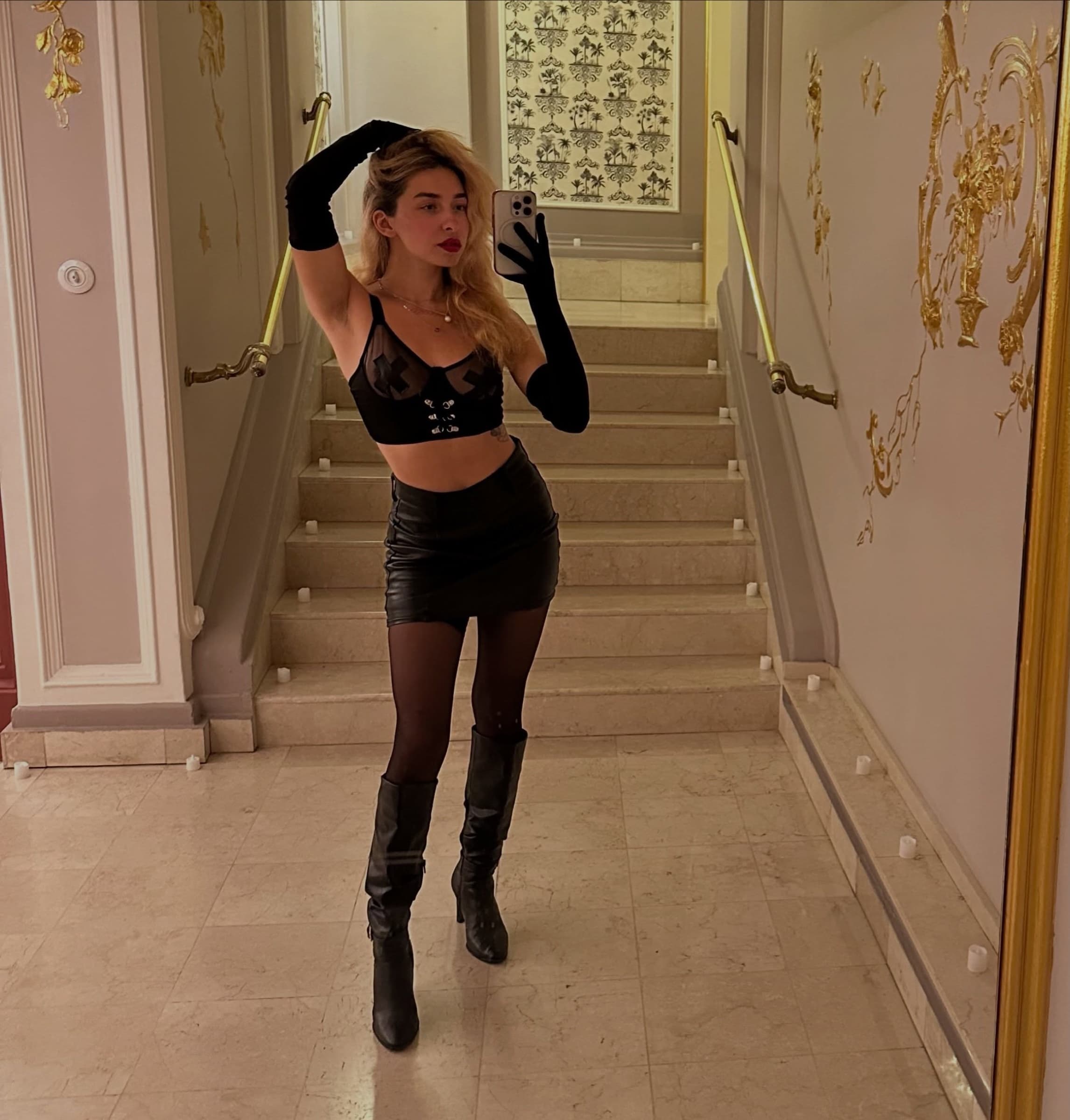 Queen Unikitty s blond vlasy, selfie v zrcadle v černém korzetu a dlouhých rukavicích